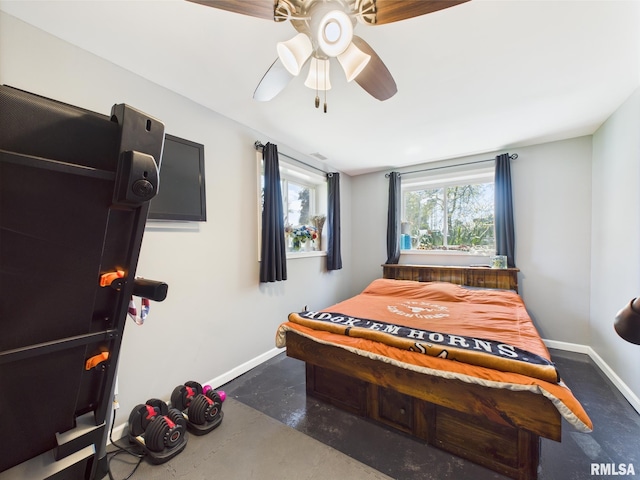 bedroom with a ceiling fan, concrete flooring, and baseboards