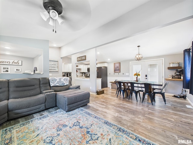 living area with a ceiling fan, light wood finished floors, recessed lighting, and baseboards