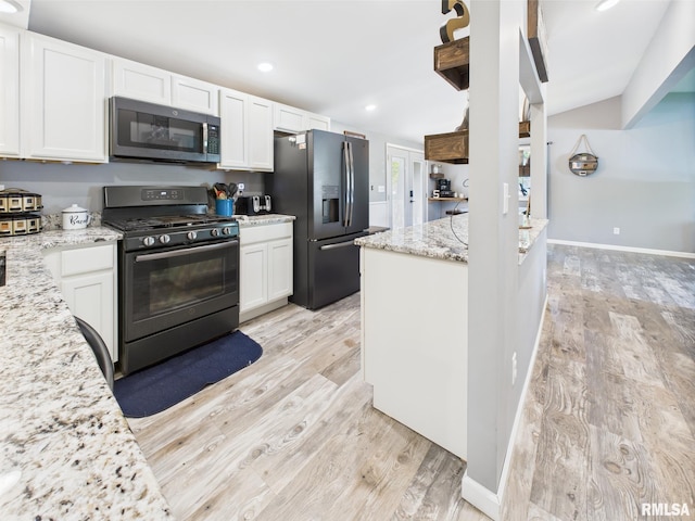 kitchen featuring light wood finished floors, light stone countertops, white cabinets, and stainless steel appliances
