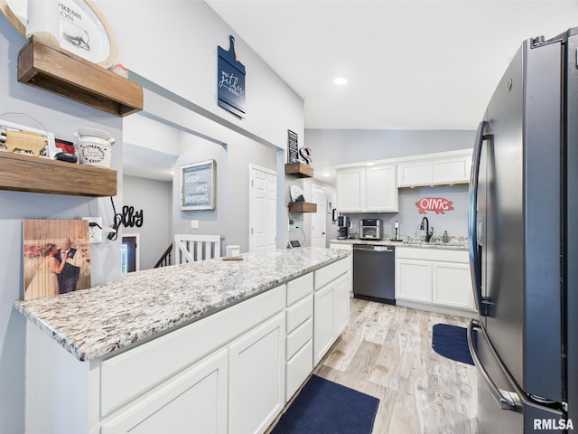 kitchen featuring light wood-style flooring, freestanding refrigerator, white cabinetry, dishwashing machine, and lofted ceiling