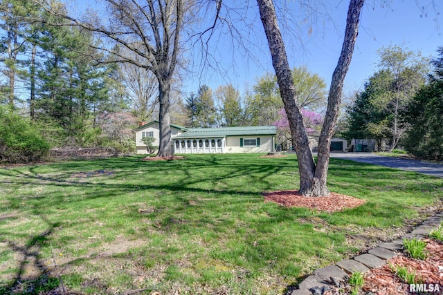 view of front of home featuring metal roof and a front yard