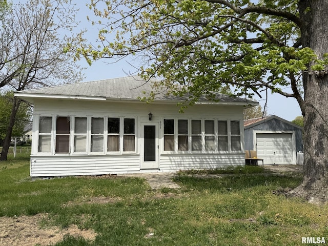 203 N 5th St, Oquawka, IL 61469 - view of front of property featuring a detached garage, an outdoor structure, and a front lawn