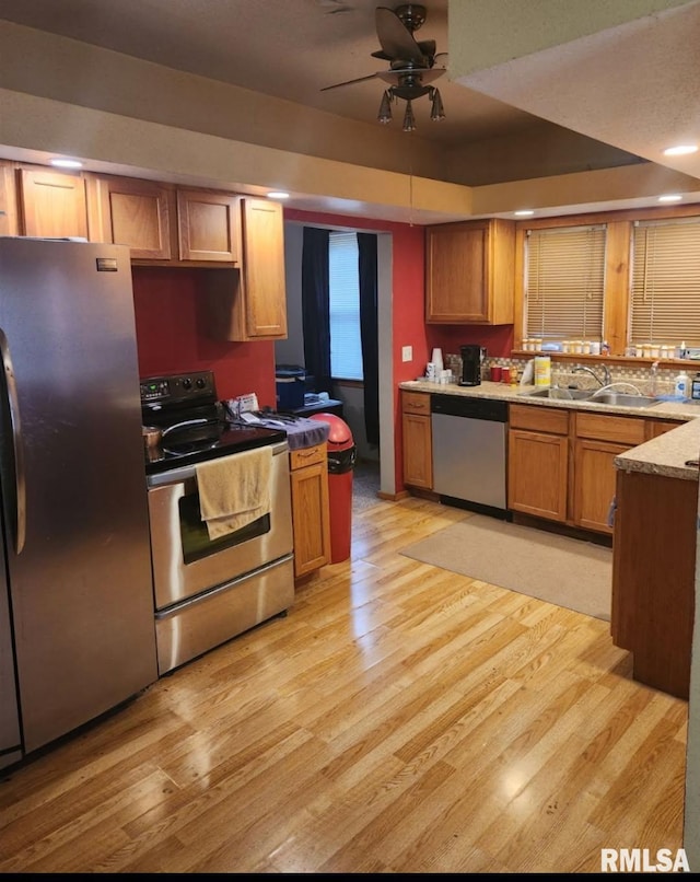 203 N 5th St, Oquawka, IL 61469 - kitchen featuring stainless steel appliances, a sink, light wood-style floors, a ceiling fan, and brown cabinets