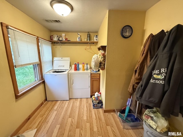 203 N 5th St, Oquawka, IL 61469 - laundry room featuring washer and clothes dryer, light wood-style flooring, baseboards, and a textured ceiling