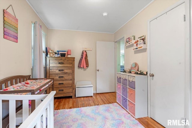bedroom featuring light wood finished floors and ornamental molding