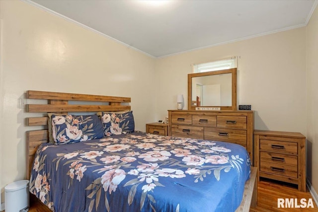 bedroom with crown molding, vaulted ceiling, and wood finished floors