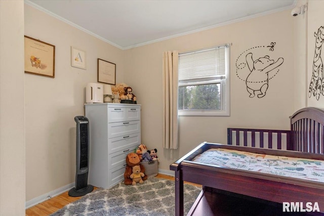 bedroom featuring baseboards, crown molding, and light wood-style flooring