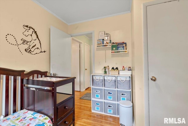 bedroom featuring ornamental molding and light wood-type flooring
