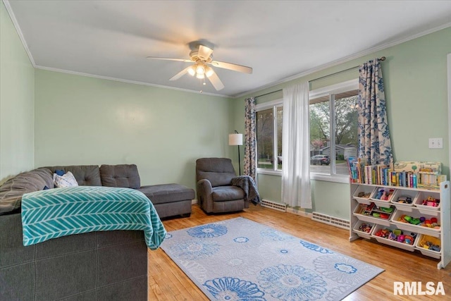 living room with visible vents, wood finished floors, ceiling fan, and ornamental molding