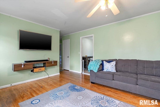 living room featuring ornamental molding, ceiling fan, wood finished floors, and baseboards