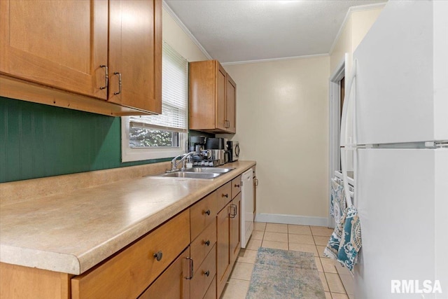 kitchen featuring a sink, light tile patterned flooring, white appliances, crown molding, and light countertops
