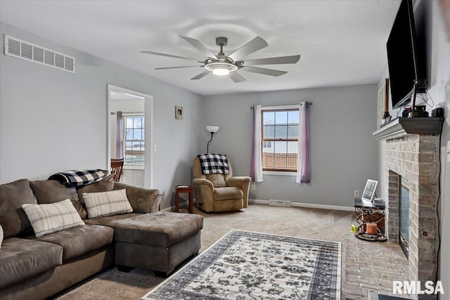 living area with a ceiling fan, visible vents, carpet floors, and a fireplace