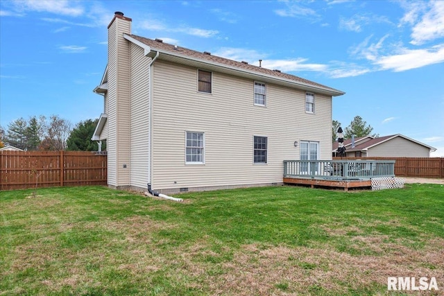 rear view of house with a chimney, a yard, a deck, and a fenced backyard