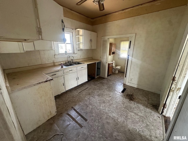 705 Olive St, Galesburg, IL 61401 - kitchen with white cabinetry, a sink, ceiling fan, light countertops, and backsplash