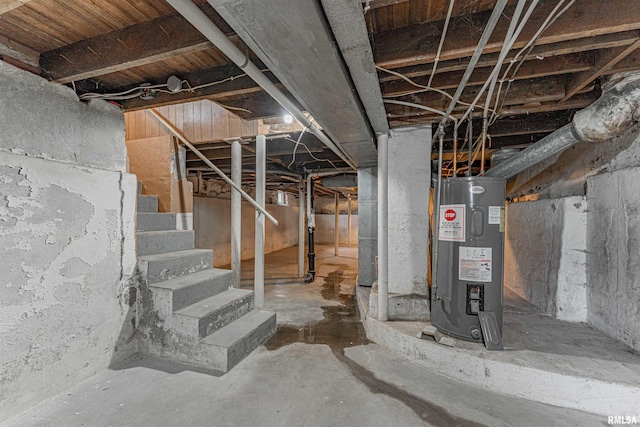 unfinished below grade area featuring water heater and stairway
