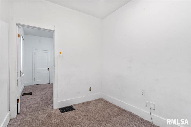 carpeted spare room with baseboards and visible vents