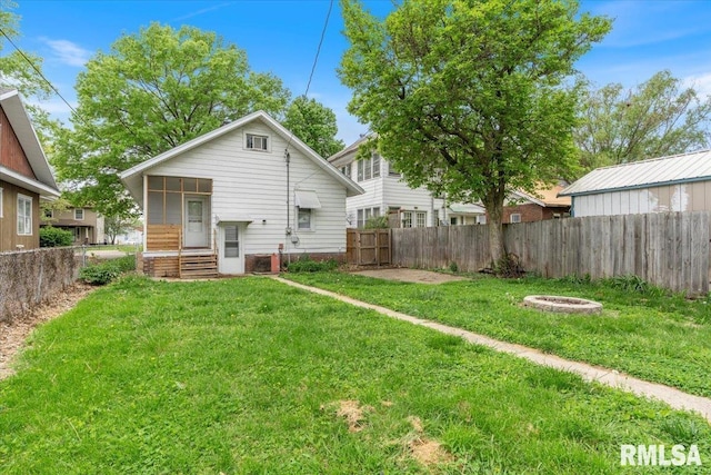 back of house with a lawn and a fenced backyard