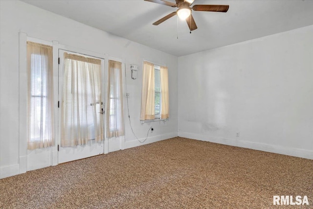 unfurnished room with carpet flooring, a ceiling fan, and baseboards