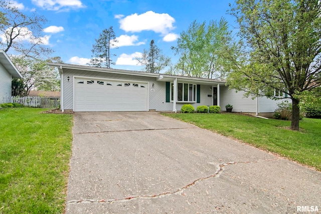 ranch-style house featuring an attached garage, fence, driveway, and a front yard