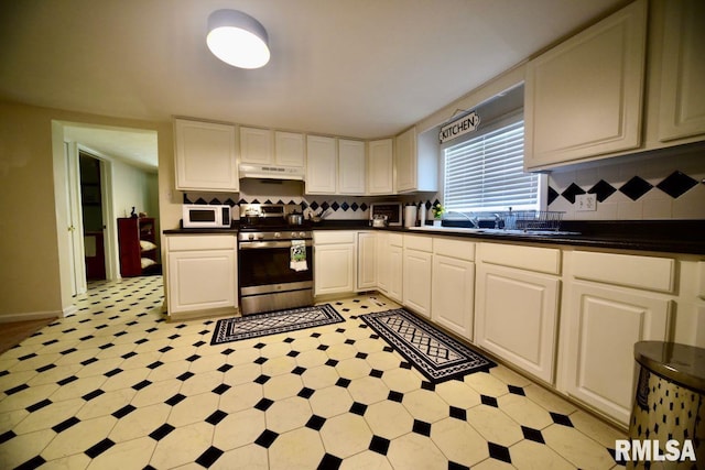 22 Roundhouse Rd, Herod, IL 62947 - kitchen with backsplash, dark countertops, stainless steel stove, white microwave, and under cabinet range hood