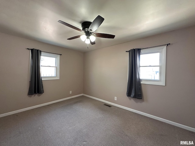 unfurnished room with visible vents, a ceiling fan, baseboards, and carpet floors