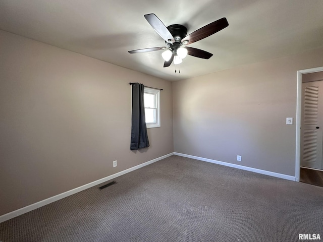 empty room with baseboards, ceiling fan, dark carpet, and visible vents
