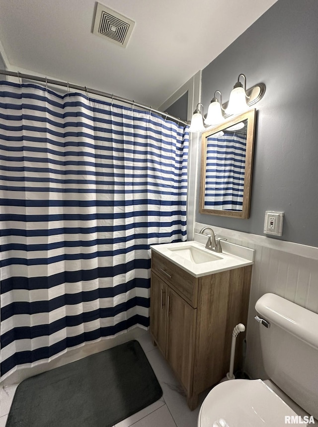 bathroom featuring wainscoting, vanity, toilet, curtained shower, and visible vents