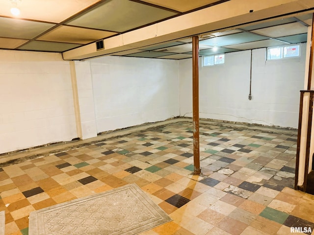 basement featuring concrete block wall and light floors