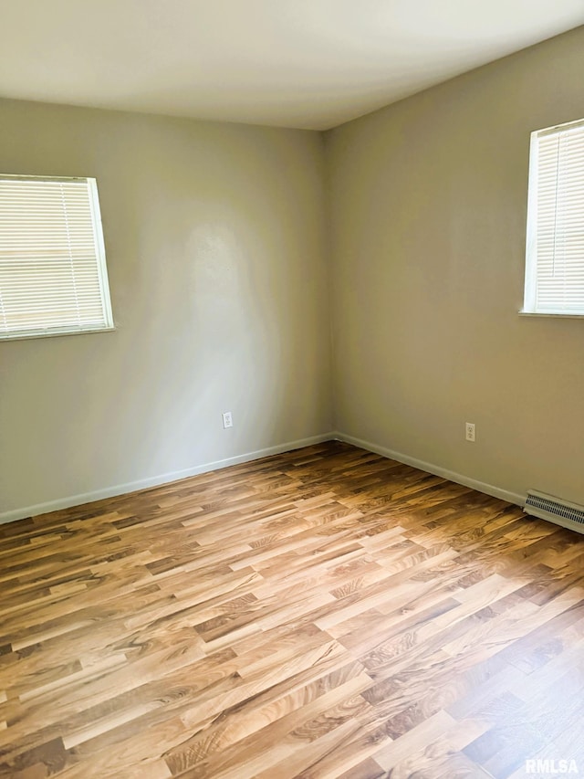 empty room featuring baseboards, visible vents, and light wood-type flooring