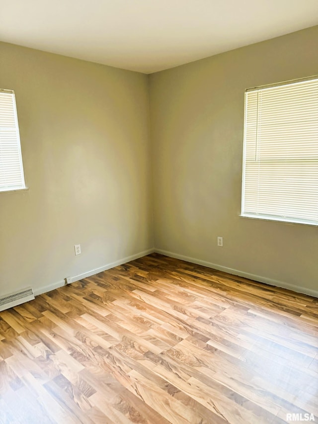 empty room featuring baseboards, visible vents, and light wood-style floors