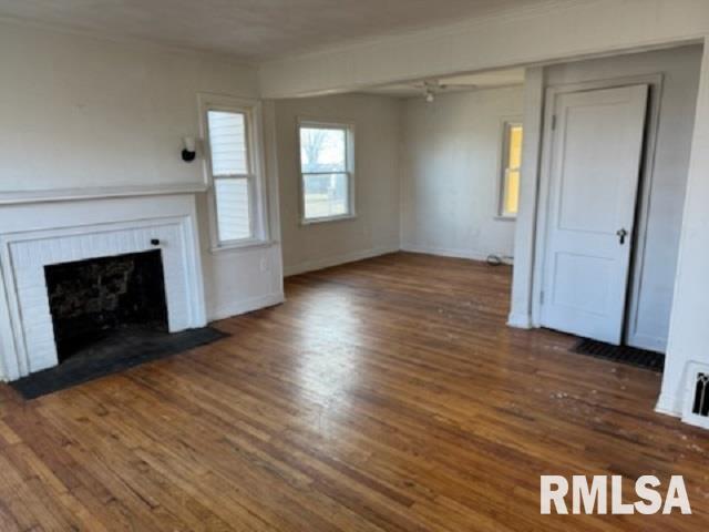 603 E Old 36th Hwy, Alexander, IL 62601 - unfurnished living room featuring baseboards, a brick fireplace, and wood finished floors