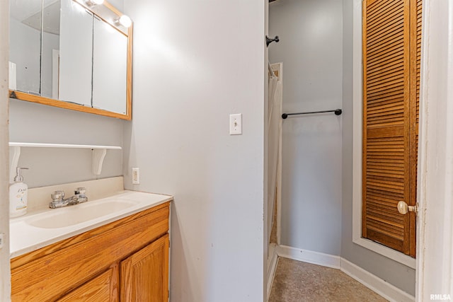 bathroom featuring baseboards, a shower with shower curtain, and vanity