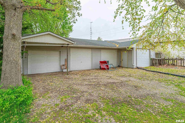 garage featuring fence and driveway