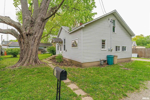 view of property exterior with fence, a yard, and a chimney