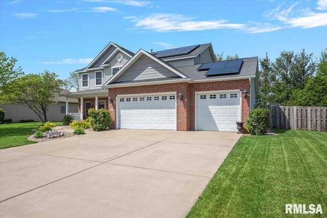 craftsman inspired home featuring a front yard, brick siding, concrete driveway, an attached garage, and solar panels