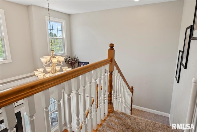 staircase featuring an inviting chandelier, baseboards, and carpet floors