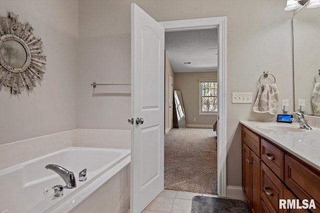 full bathroom featuring baseboards, tile patterned flooring, a bath, and vanity