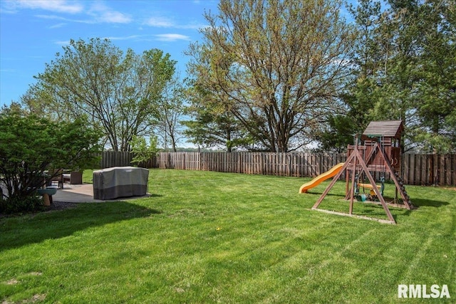 view of yard with a fenced backyard, a patio, and a playground