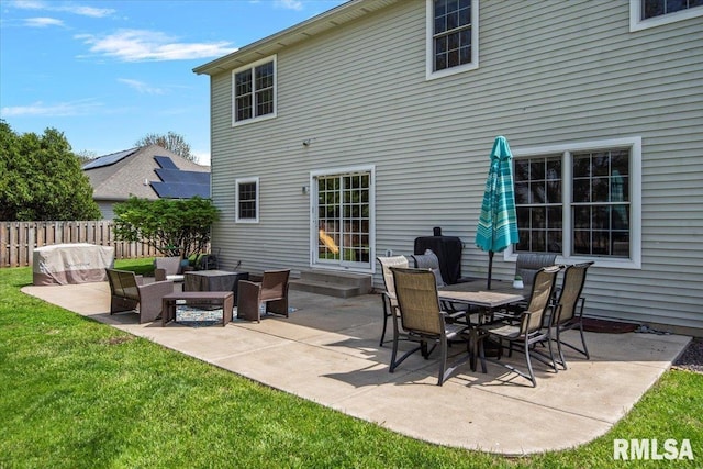 rear view of property featuring fence, a patio, a lawn, and an outdoor living space