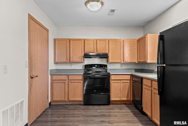 kitchen featuring under cabinet range hood, light countertops, black appliances, and visible vents