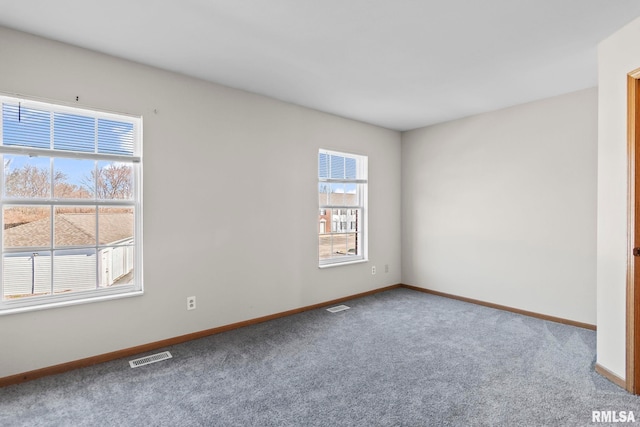 carpeted spare room featuring baseboards and visible vents