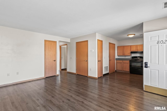 unfurnished living room featuring visible vents, dark wood-style flooring, and baseboards