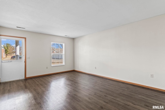 unfurnished room with visible vents, baseboards, wood finished floors, and a healthy amount of sunlight