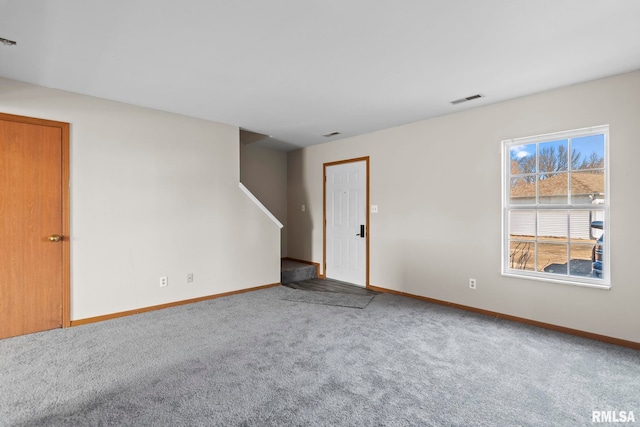 carpeted empty room featuring stairway, baseboards, and visible vents