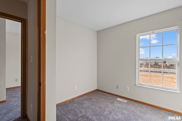 empty room with carpet flooring, baseboards, and visible vents