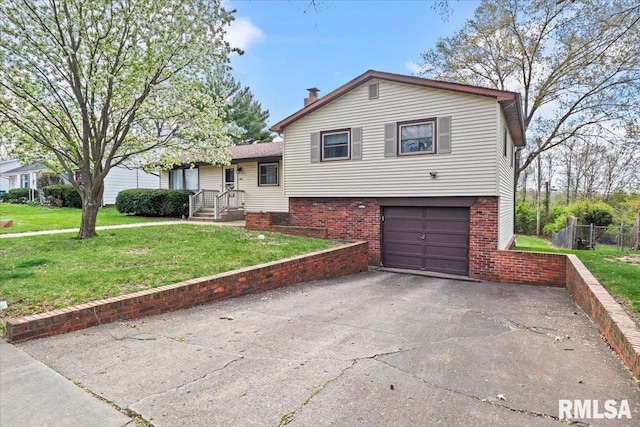 split level home featuring a garage, fence, driveway, and a front lawn