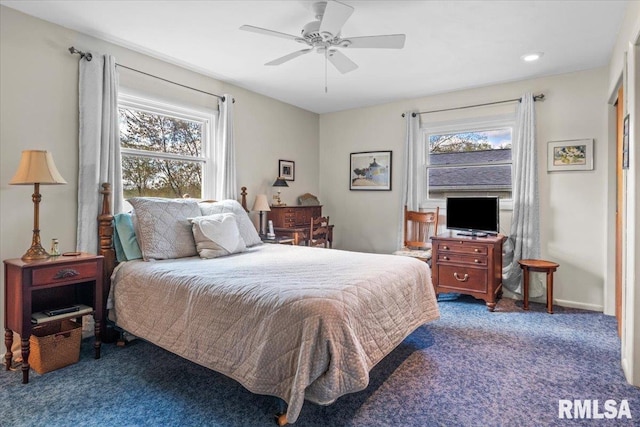 carpeted bedroom featuring multiple windows and a ceiling fan