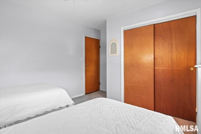 bedroom with carpet flooring, baseboards, and a closet