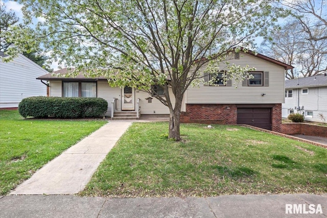 split level home with an attached garage, a front lawn, and brick siding