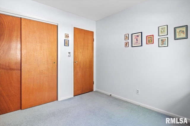 unfurnished bedroom with baseboards, carpet, and a closet